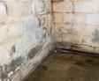 wet basement with leaking walls and bubbling paint