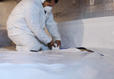 Crew installing a vapor barrier in the crawlspace.