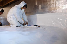 Crew installing crawlspace vapor barrier.