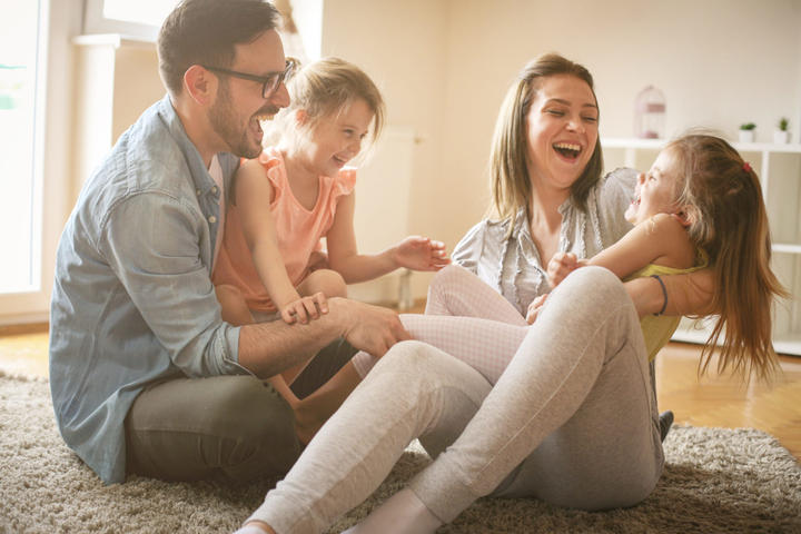 Family laughing inside of their home.
