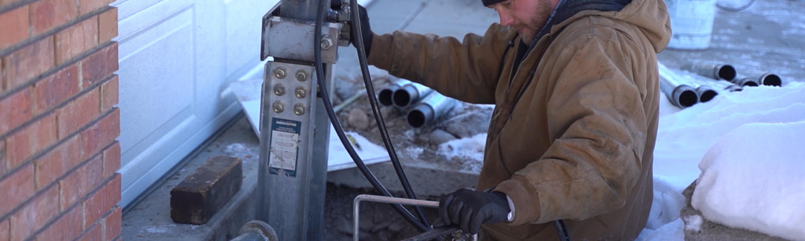 CFI is installing push pier in front of the driveway in the snow.