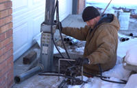 CFI is installing push pier in front of the driveway in the snow.