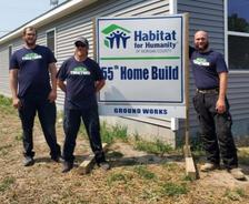 Indiana Foundation Service employees stand in front of a Habitat for Humanity of Morgan County sign for the 55th home built