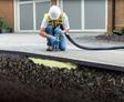 man installing polyurethane foam under concrete driveway