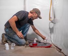 crew member installing a basement sump pump