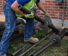 crew member picking up helical pier for foundation repair