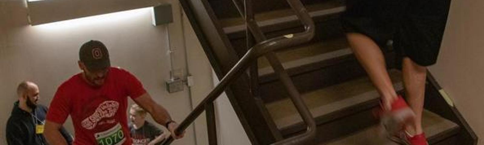 People running up a stairwell during a race event in a building.