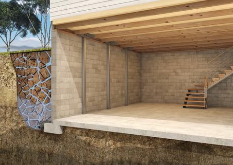 Cutaway of a house foundation with a view of stone-filled drainage, concrete walls, and wooden stairs.