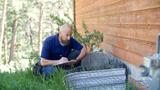 man inspecting a house foundation