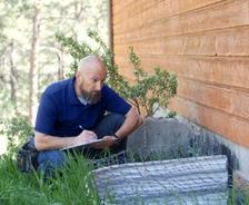 man inspecting a house foundation
