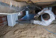 A worker fixing a crawl space.