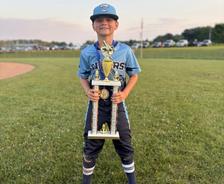 smiling Twinsburg Tigers 10U teammate holding a championship trophy