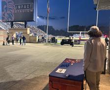 Ohio Basement Authority employee standing at a company table watching the 2025 Marysville High School Homecoming football game