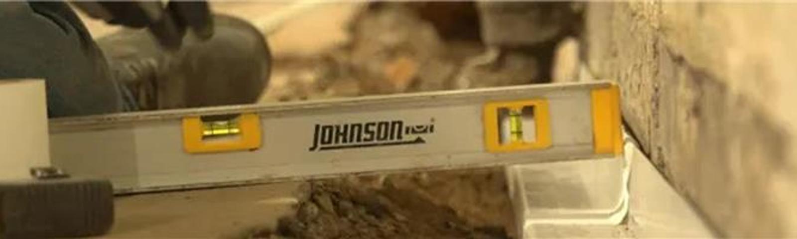 A close-up of a level tool checking alignment on a wall during a construction project.